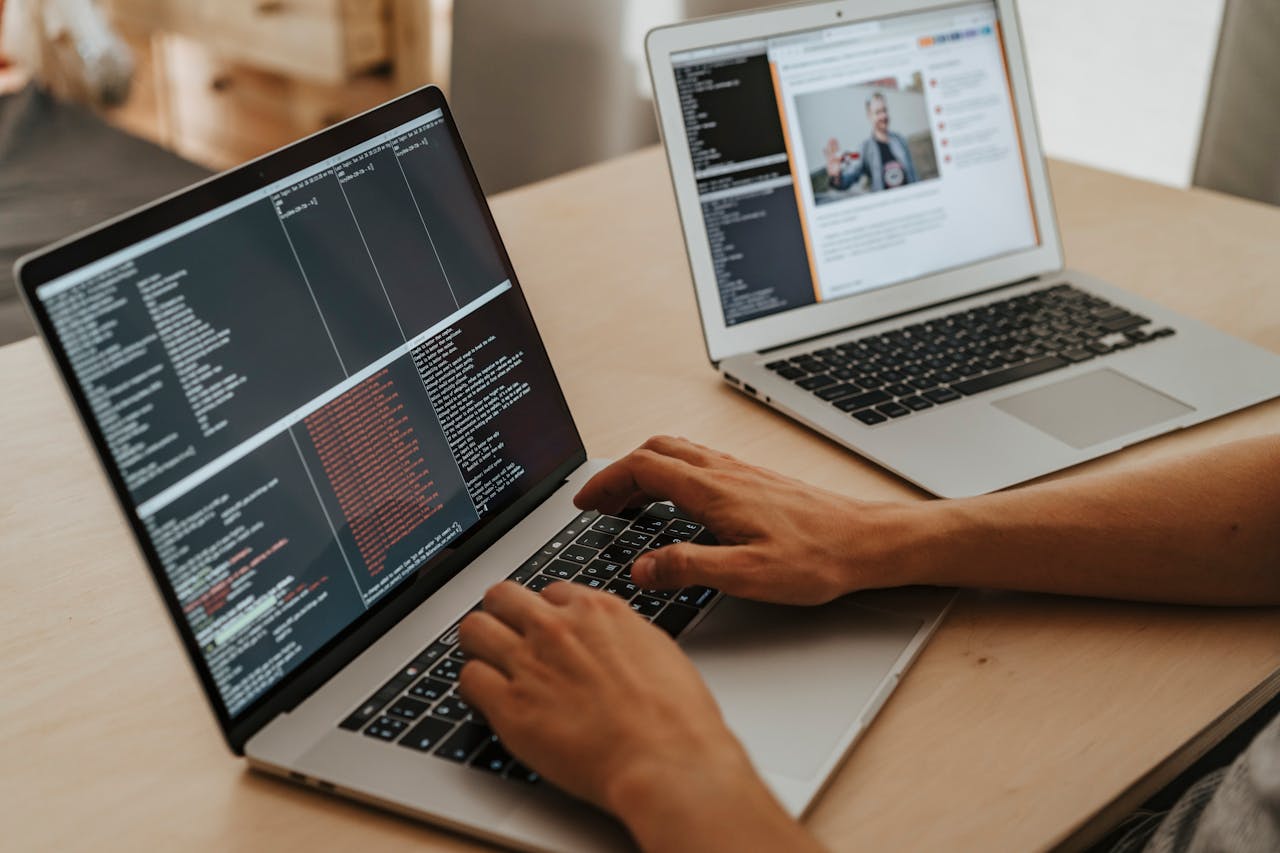 Home A developer working on a laptop, typing code, showcasing programming and technology skills.